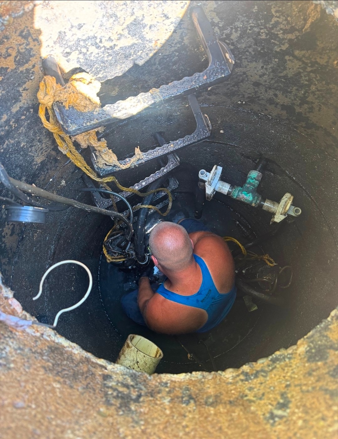 CJ working inside a commercial grease well during an urgent pump replacement